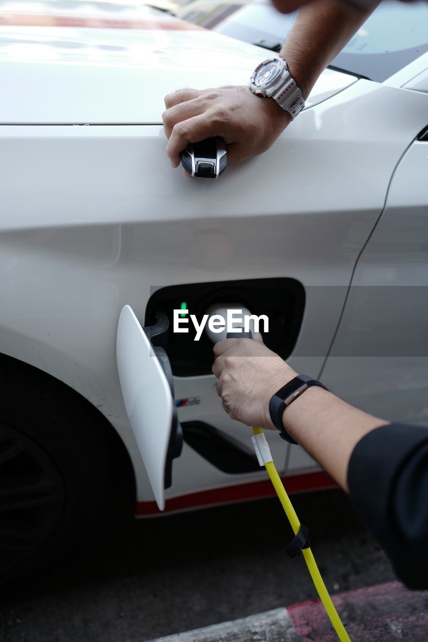 Cropped hand charging electric car