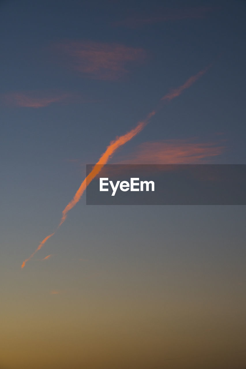 LOW ANGLE VIEW OF VAPOR TRAIL IN SKY DURING SUNSET