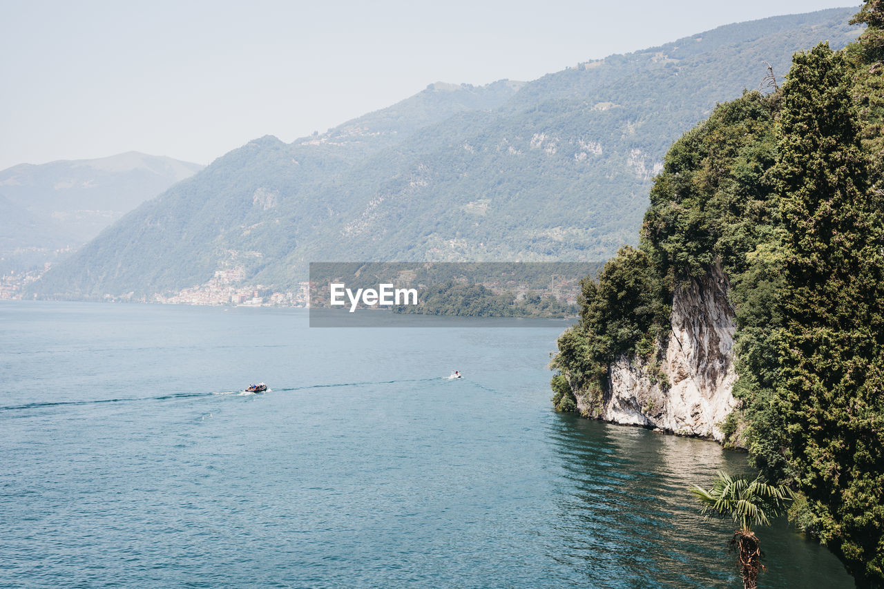 Scenic view of sea and mountains against sky