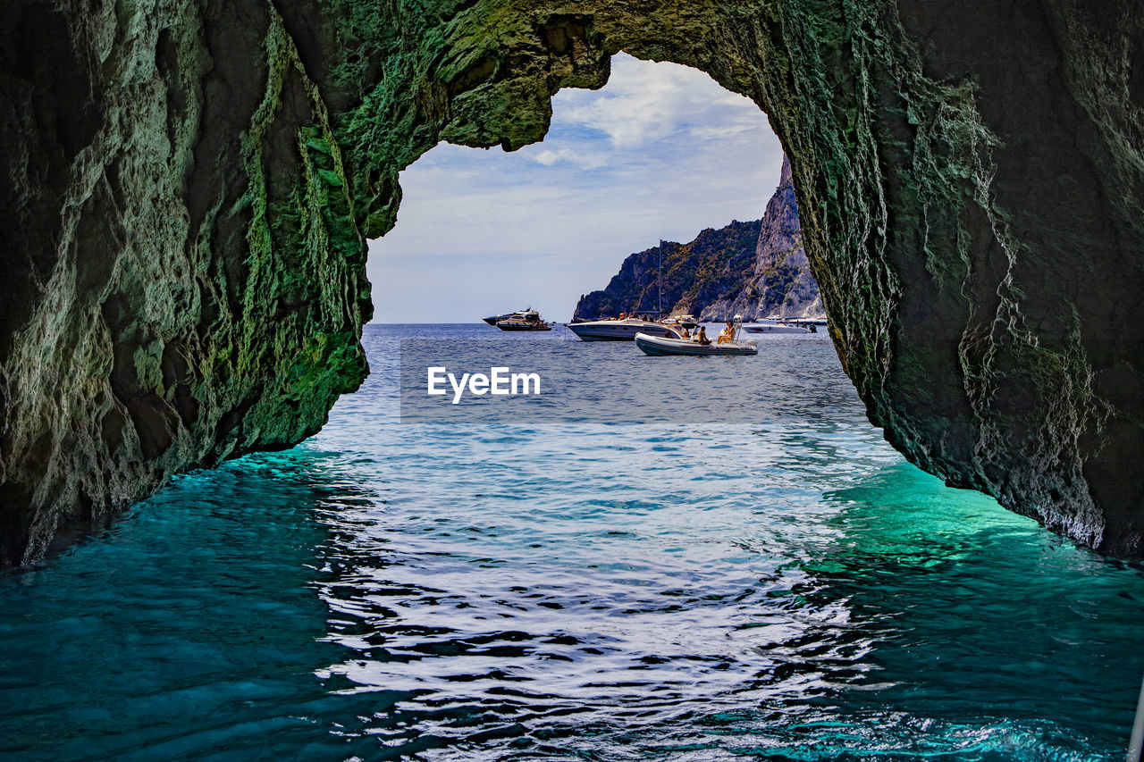 Scenic view of sea cave against sky
