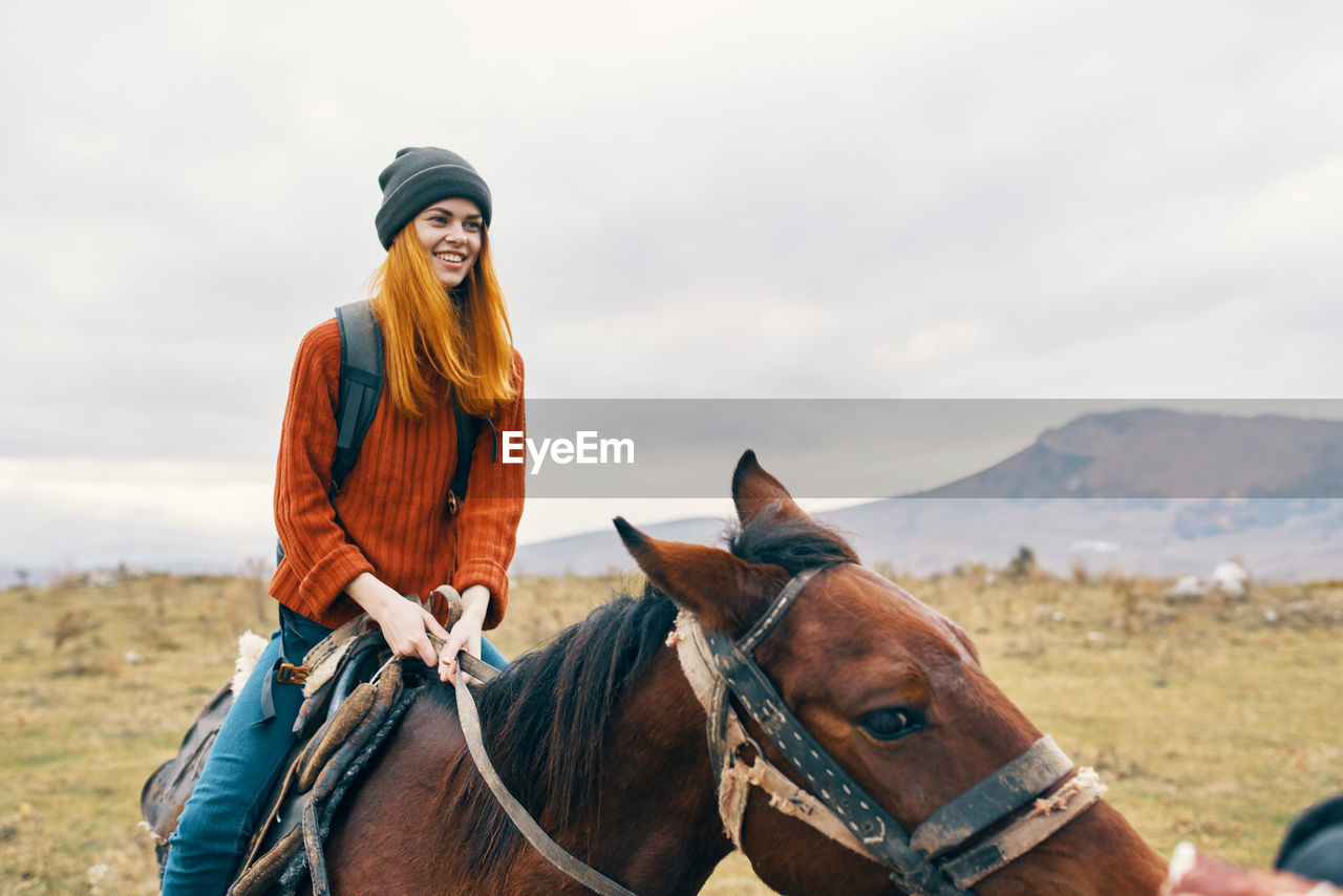 MAN RIDING HORSE IN A THE BACKGROUND