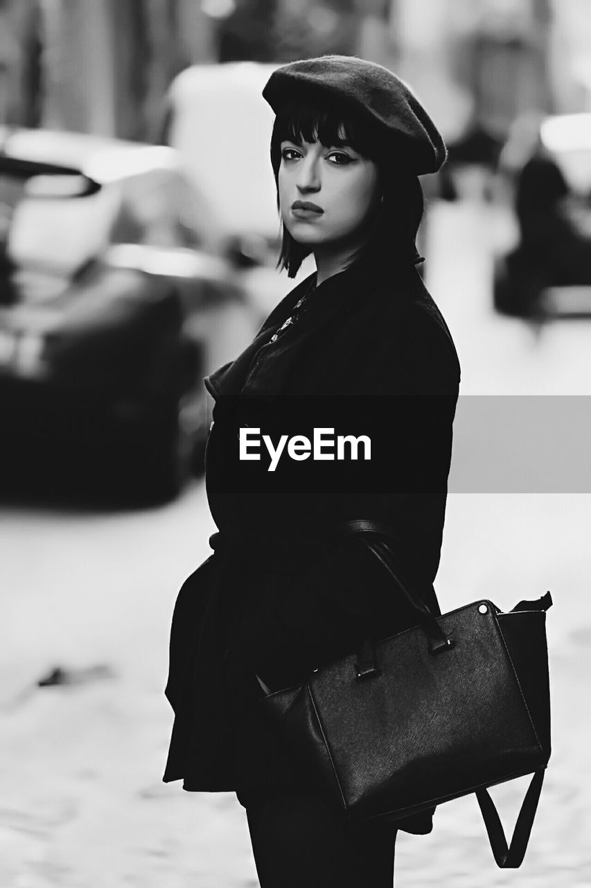 Portrait of young woman standing on street