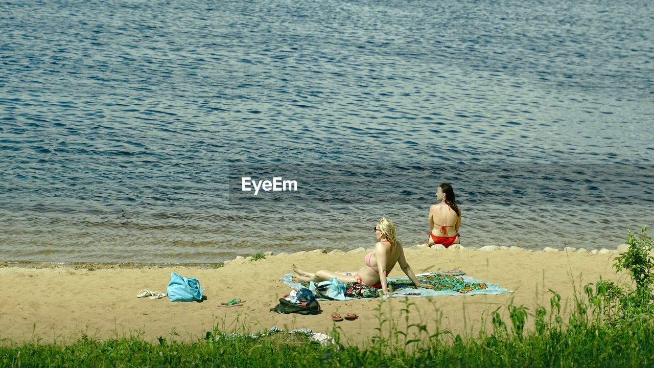 WOMEN SITTING ON BEACH