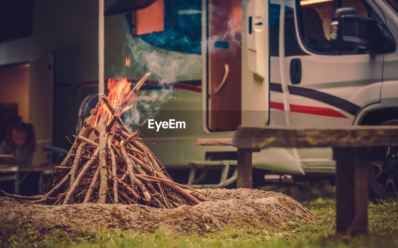 Close-up of burning firewood by car