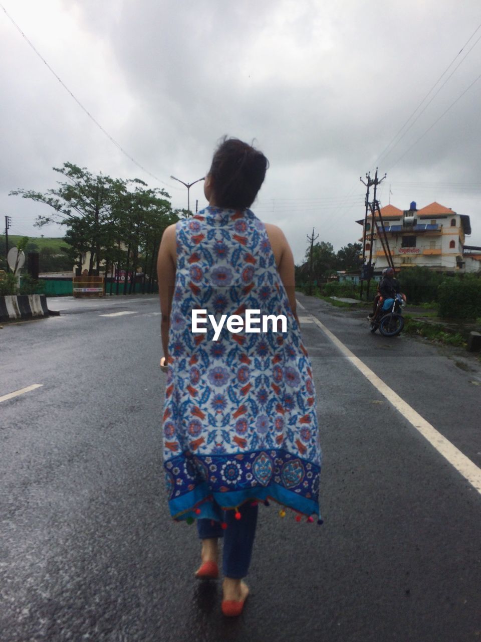 REAR VIEW OF WOMAN WALKING ON STREET