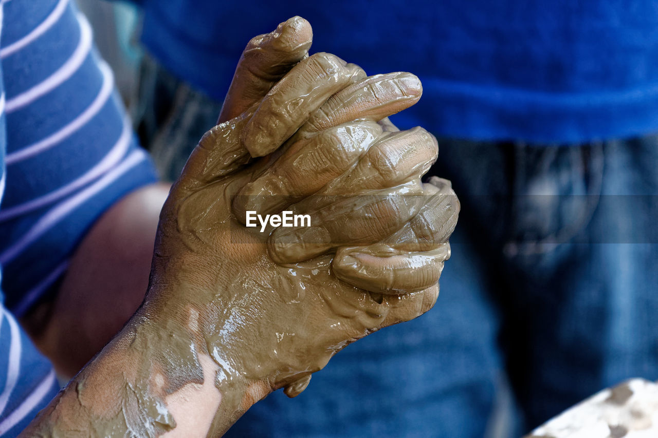 Close-up of mud on human hands