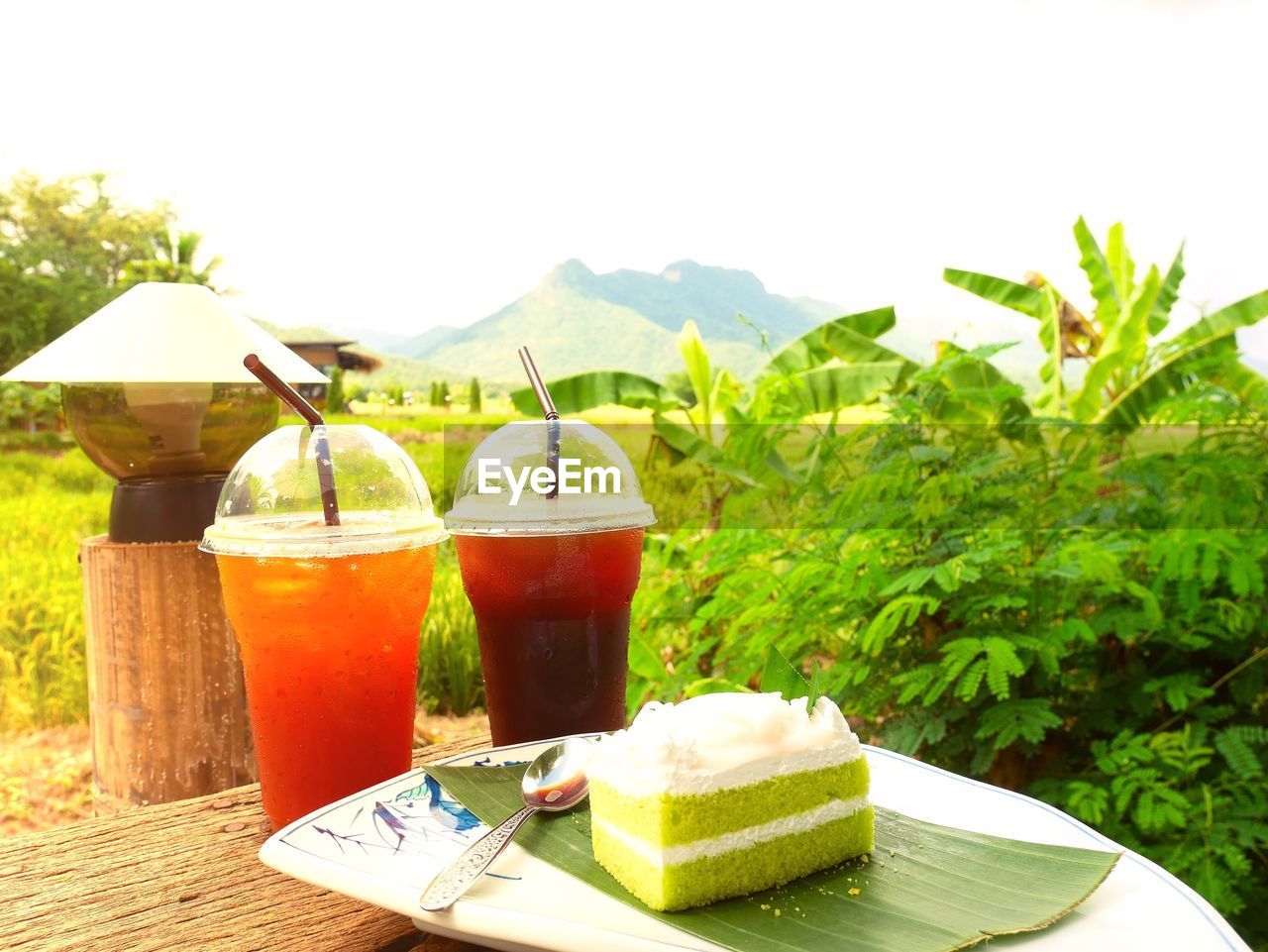 CLOSE-UP OF DRINK ON TABLE AGAINST MOUNTAIN