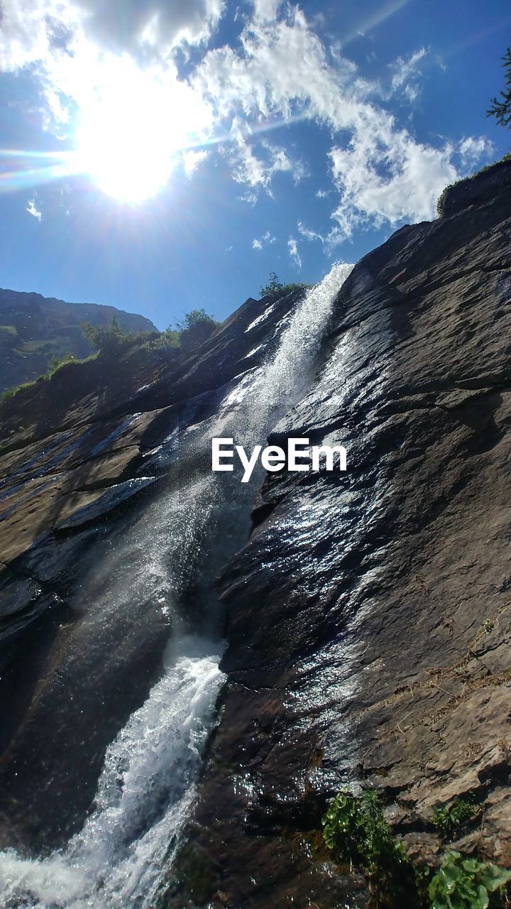 Scenic view of waterfall against sky