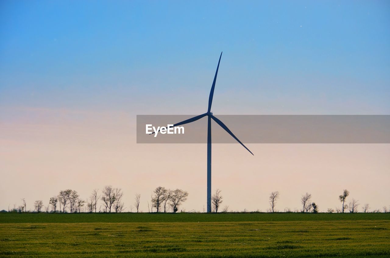 WIND TURBINES ON FIELD AGAINST CLEAR SKY
