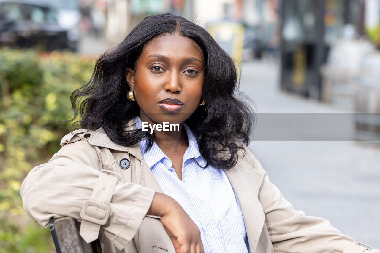 portrait of young woman standing in city