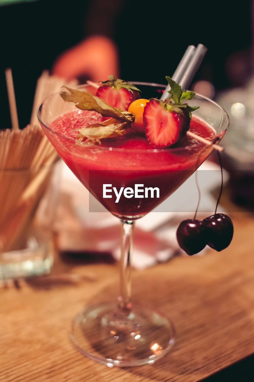 Close-up of fruit drink in martini glass on table