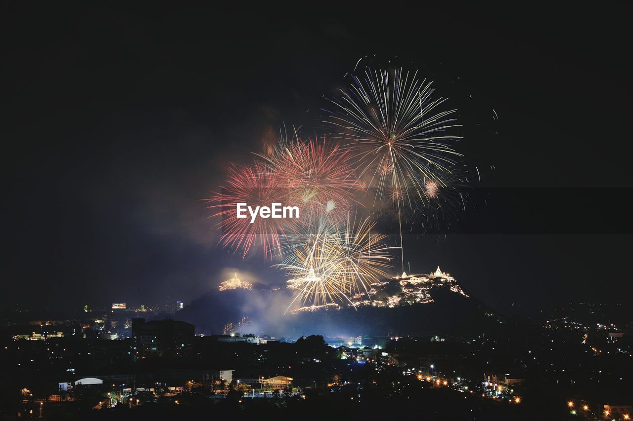 Firework display above buildings in city at night