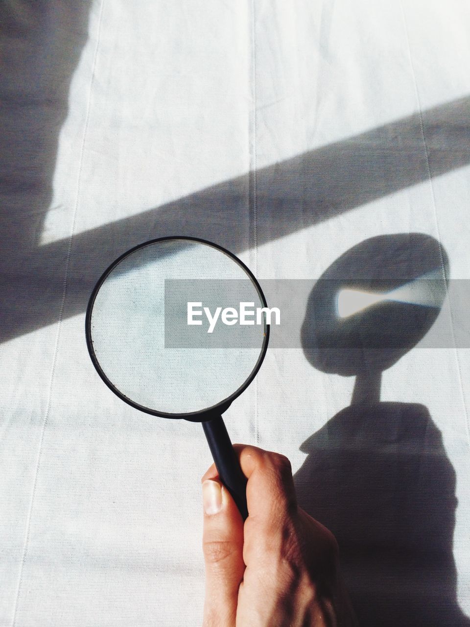 Cropped image of person holding magnifying glass