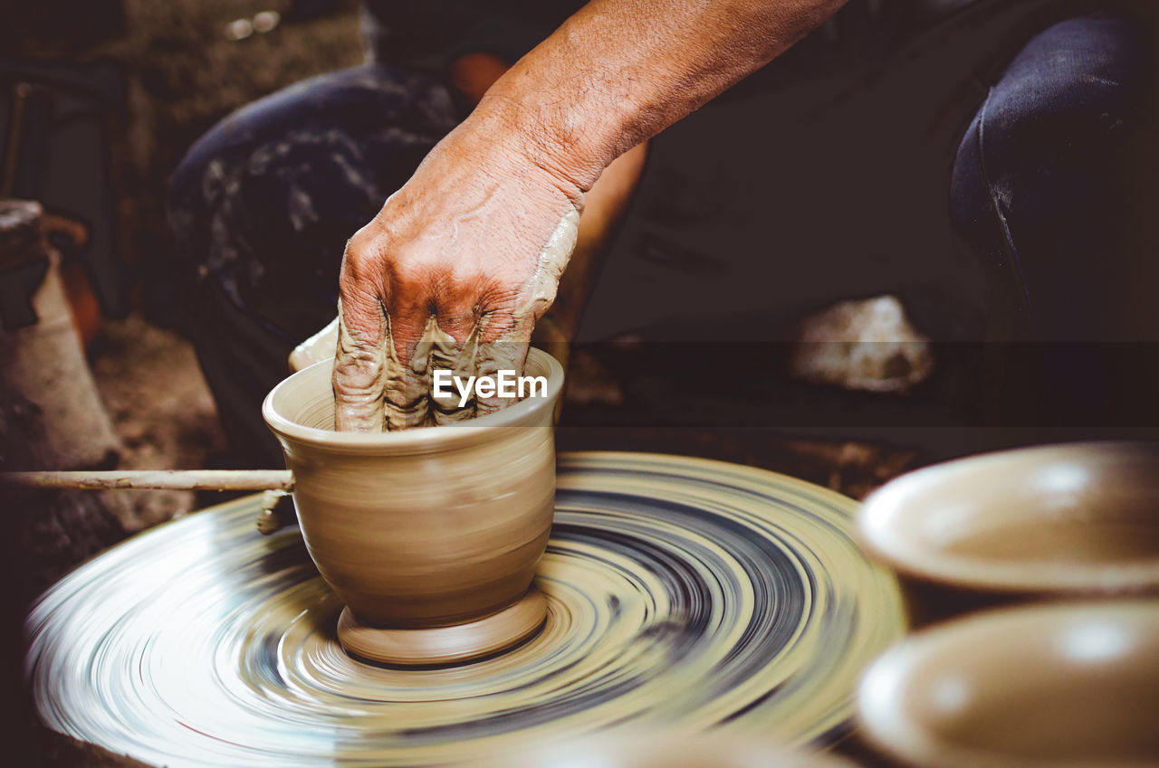 Close-up of artist making pot at workshop