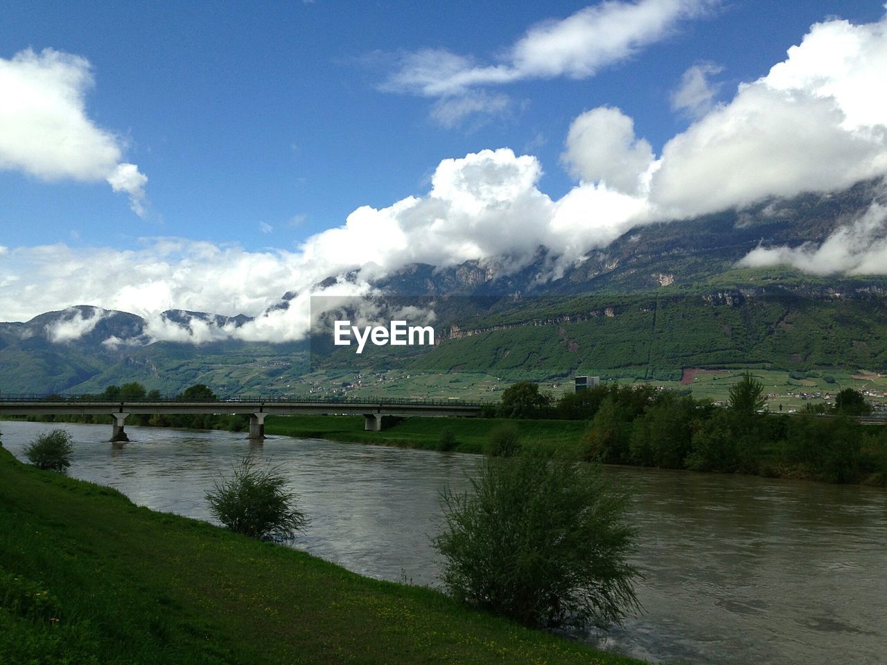 Idyllic view of clouds over mountains by river