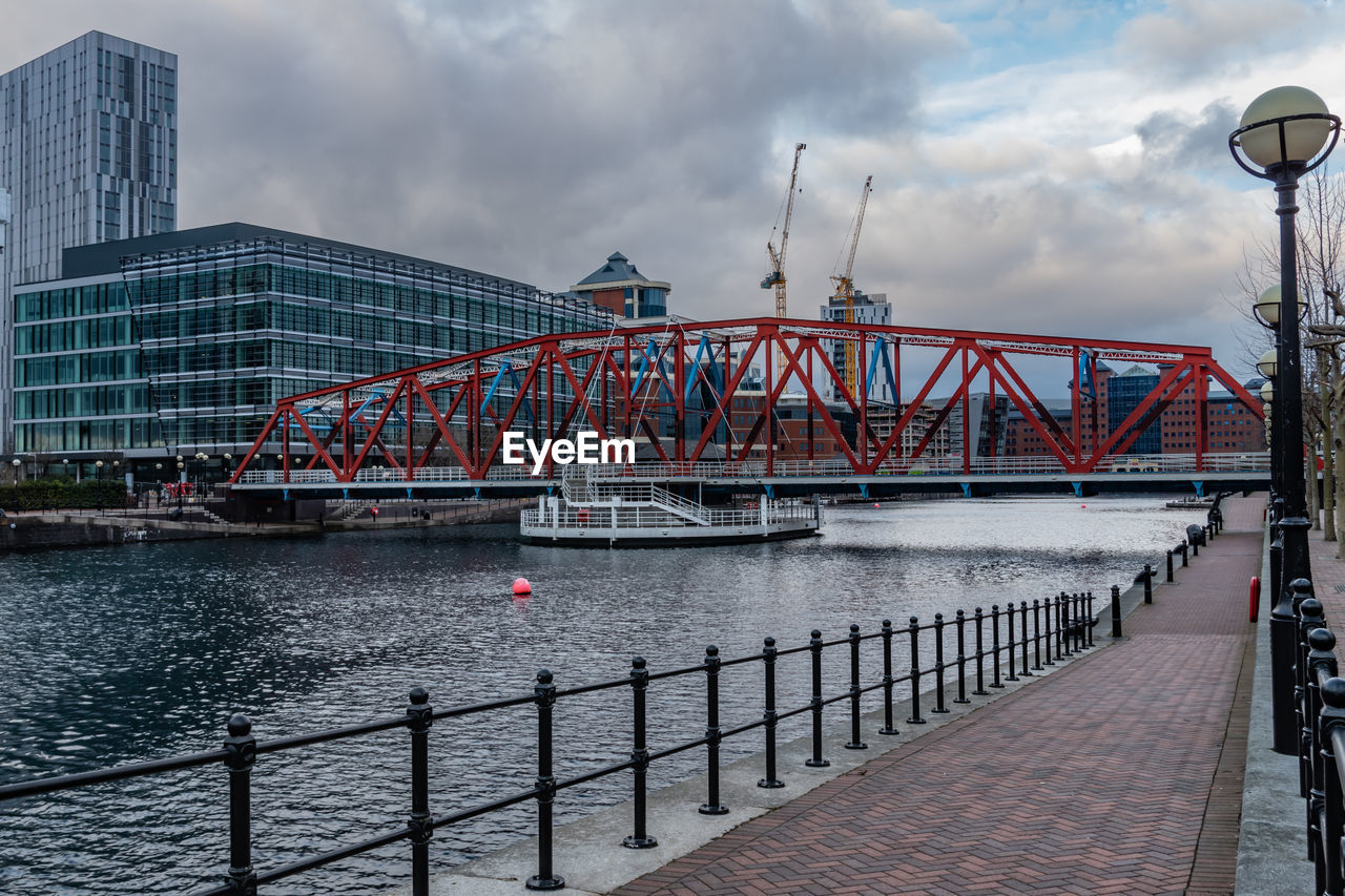 BRIDGE OVER RIVER IN CITY AGAINST SKY