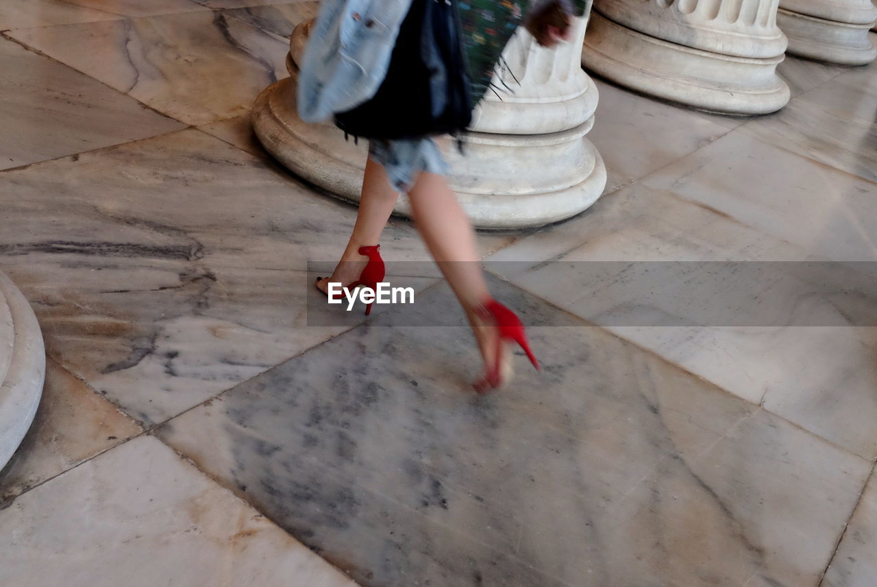 Low section of woman walking on tiled floor