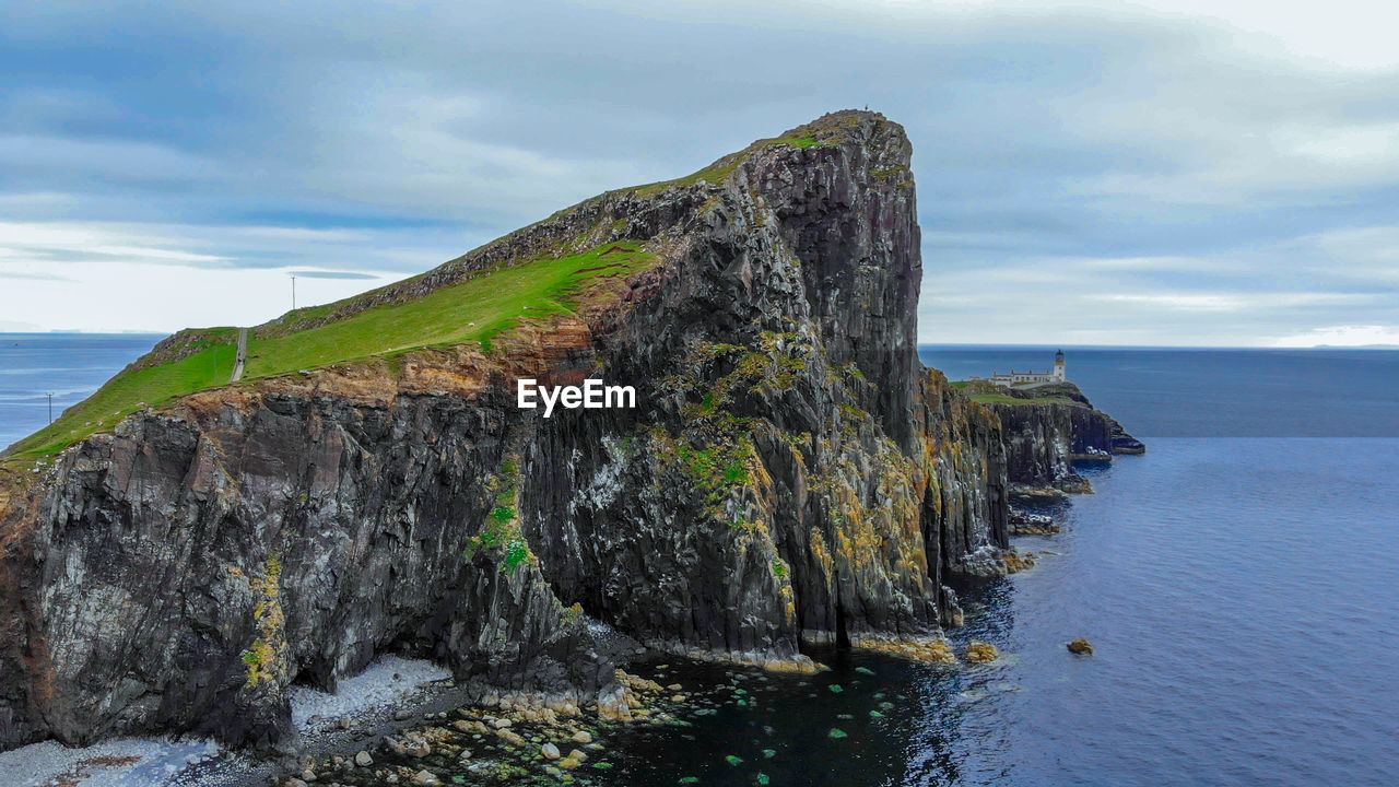 SCENIC VIEW OF SEA BY ROCK FORMATION AGAINST SKY