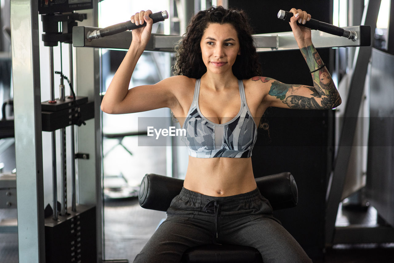 Young woman lifting weights 