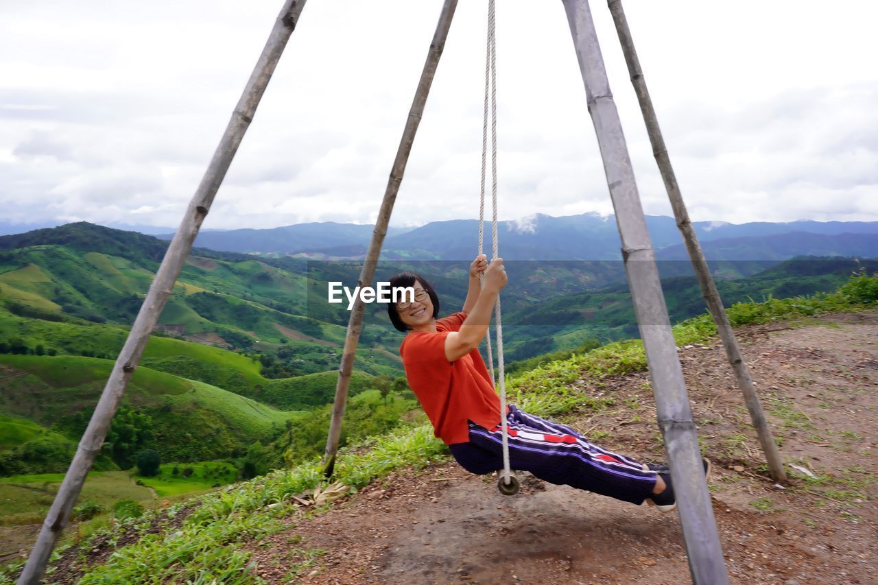 MAN ON LANDSCAPE AGAINST MOUNTAIN RANGE