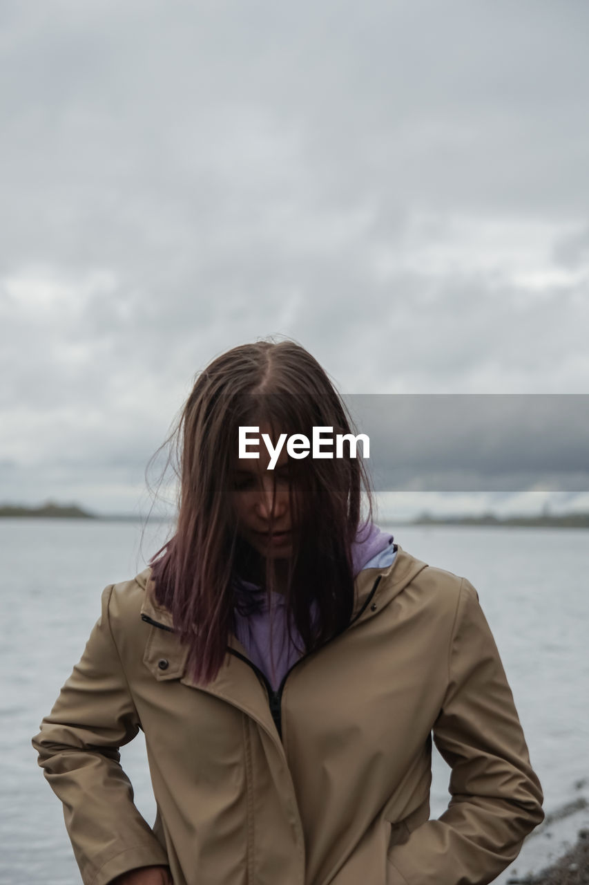 Portrait of woman standing in sea against sky