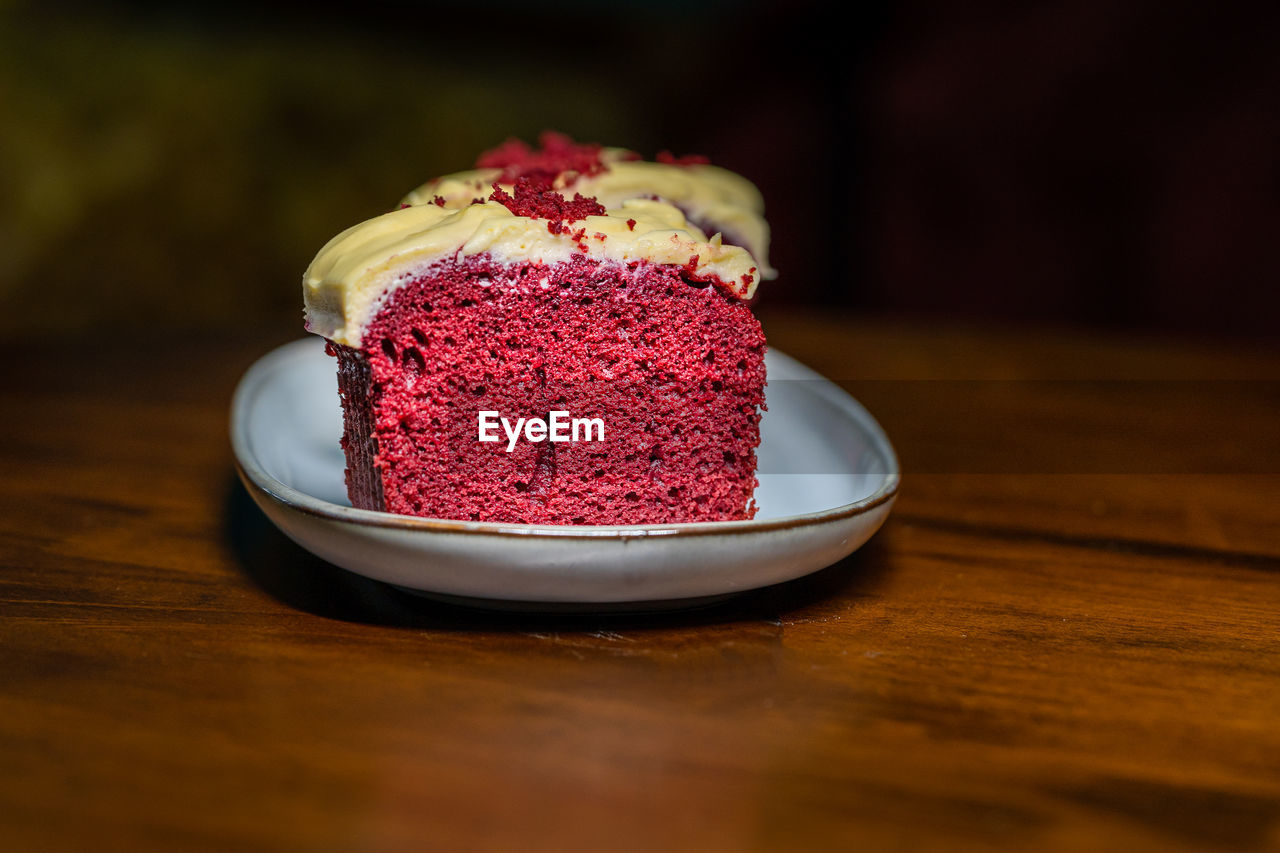 Slices of red velvet cake in a plate on a wooden table