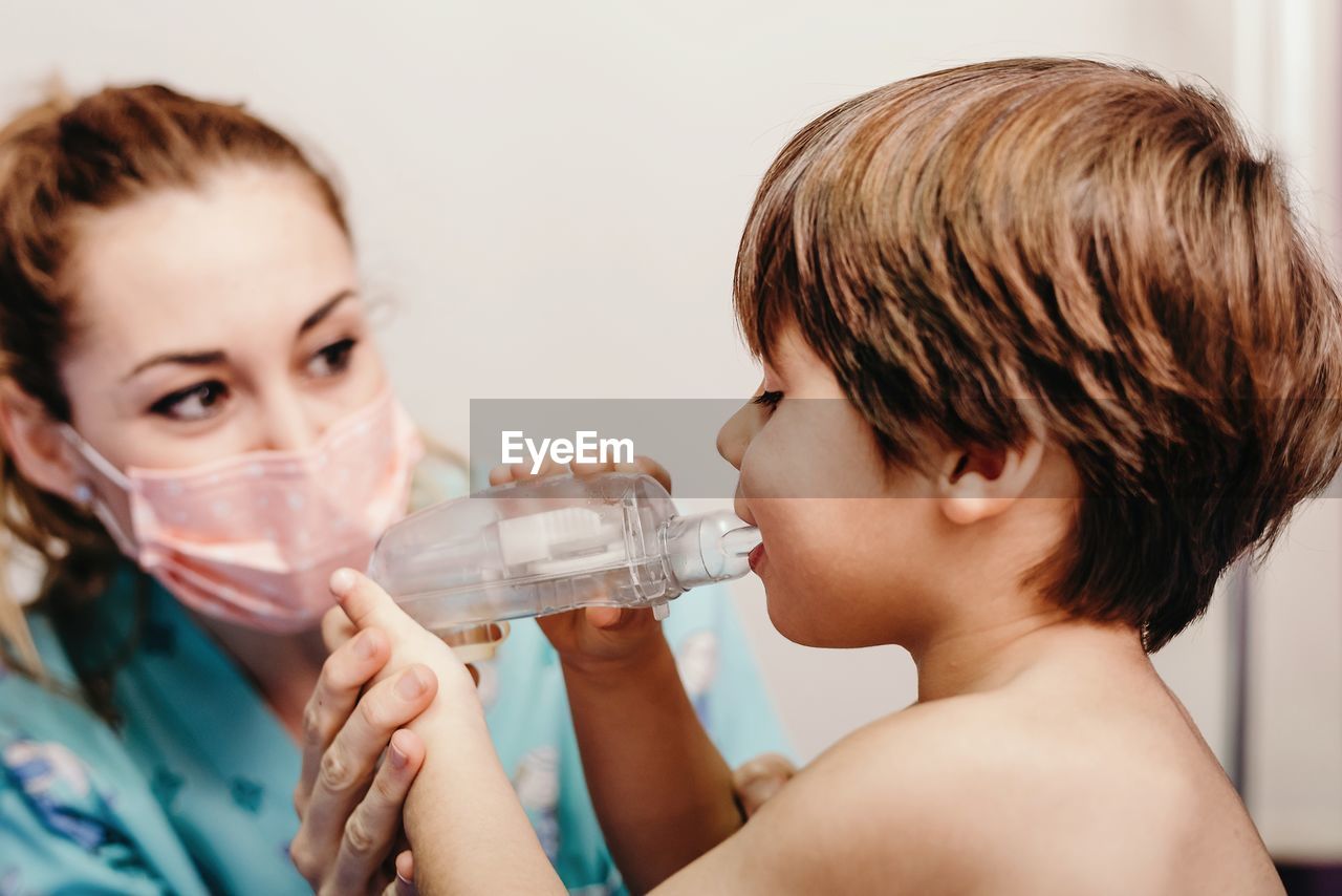 Little kid using inhaler in clinic during check up