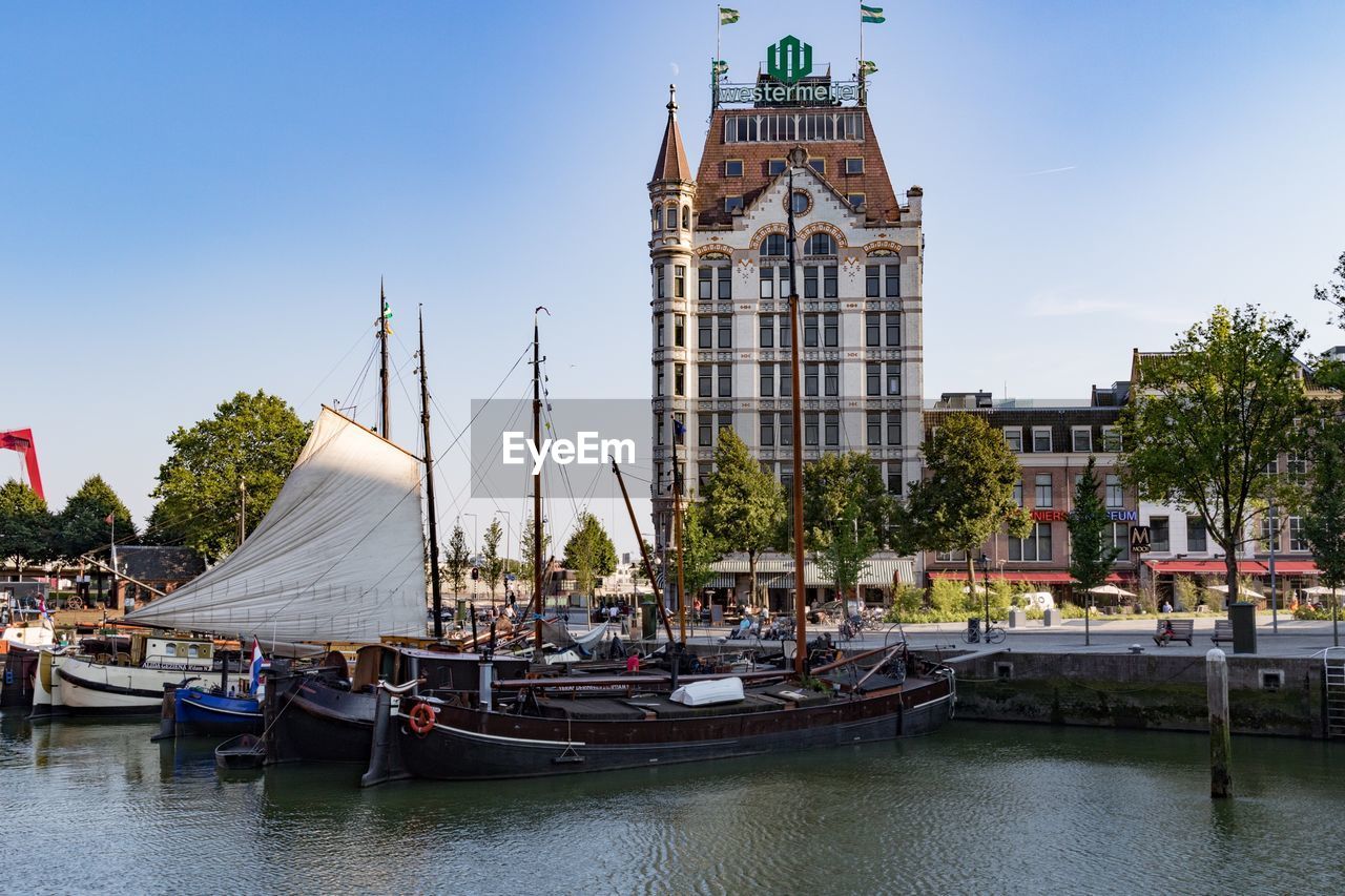 BOATS IN RIVER WITH BUILDINGS IN FOREGROUND