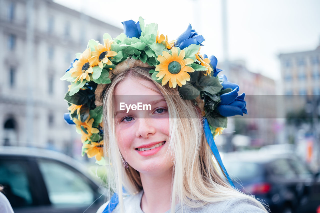 Rome, italy - may 22, 2022 a pretty blonde ukrainian girl wearing colorful flower crown wreath at