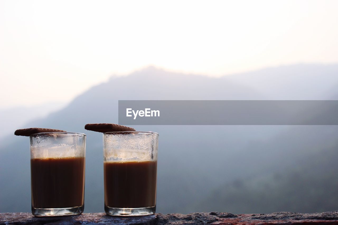 Close-up of tea and biscuits in mountains against sky