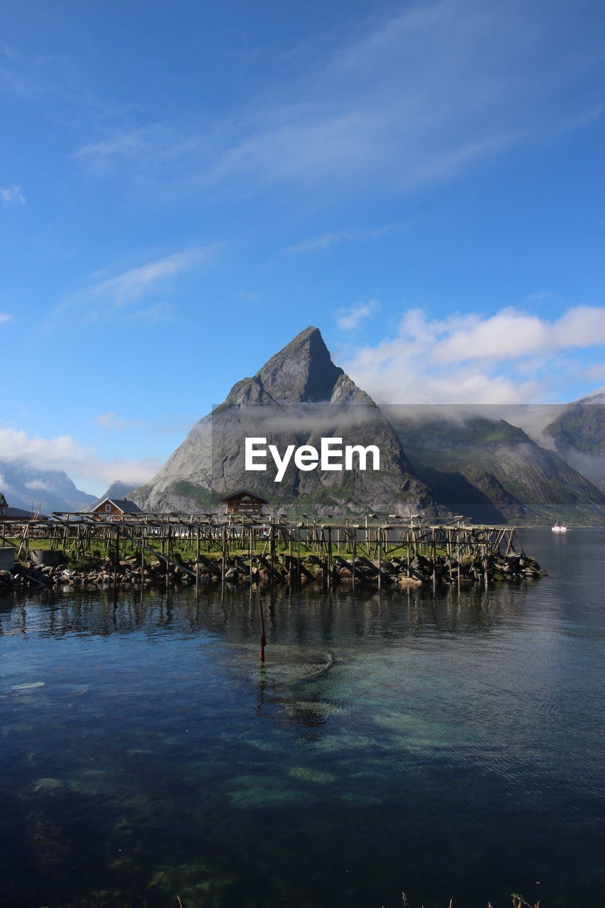 Scenic view of lake and mountains against blue sky