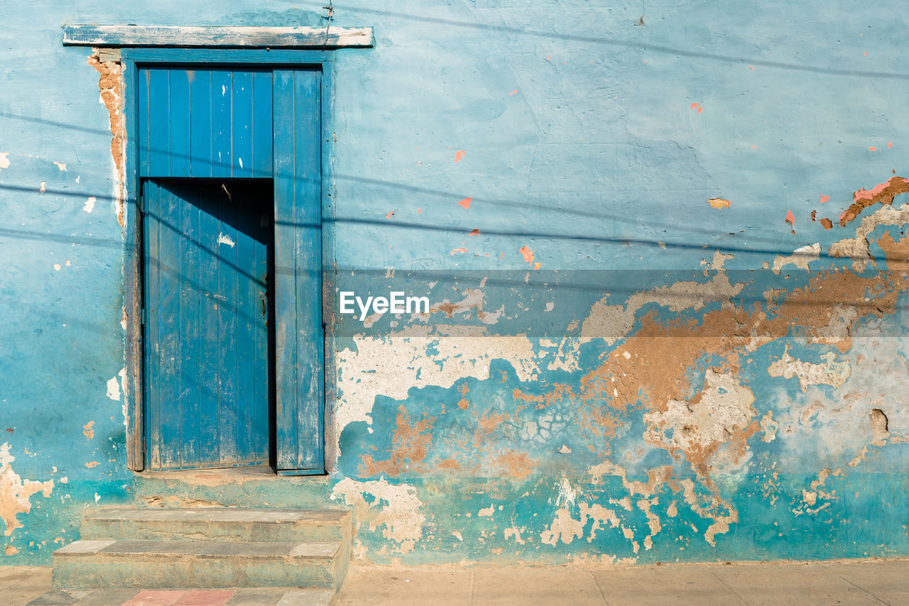 Old weathered blue wall with door