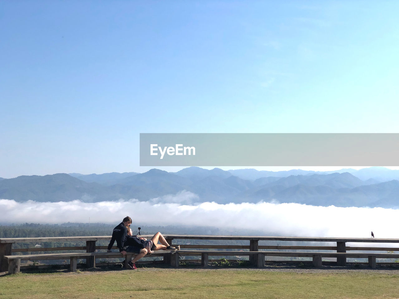 PEOPLE SITTING ON BENCH LOOKING AT VIEW