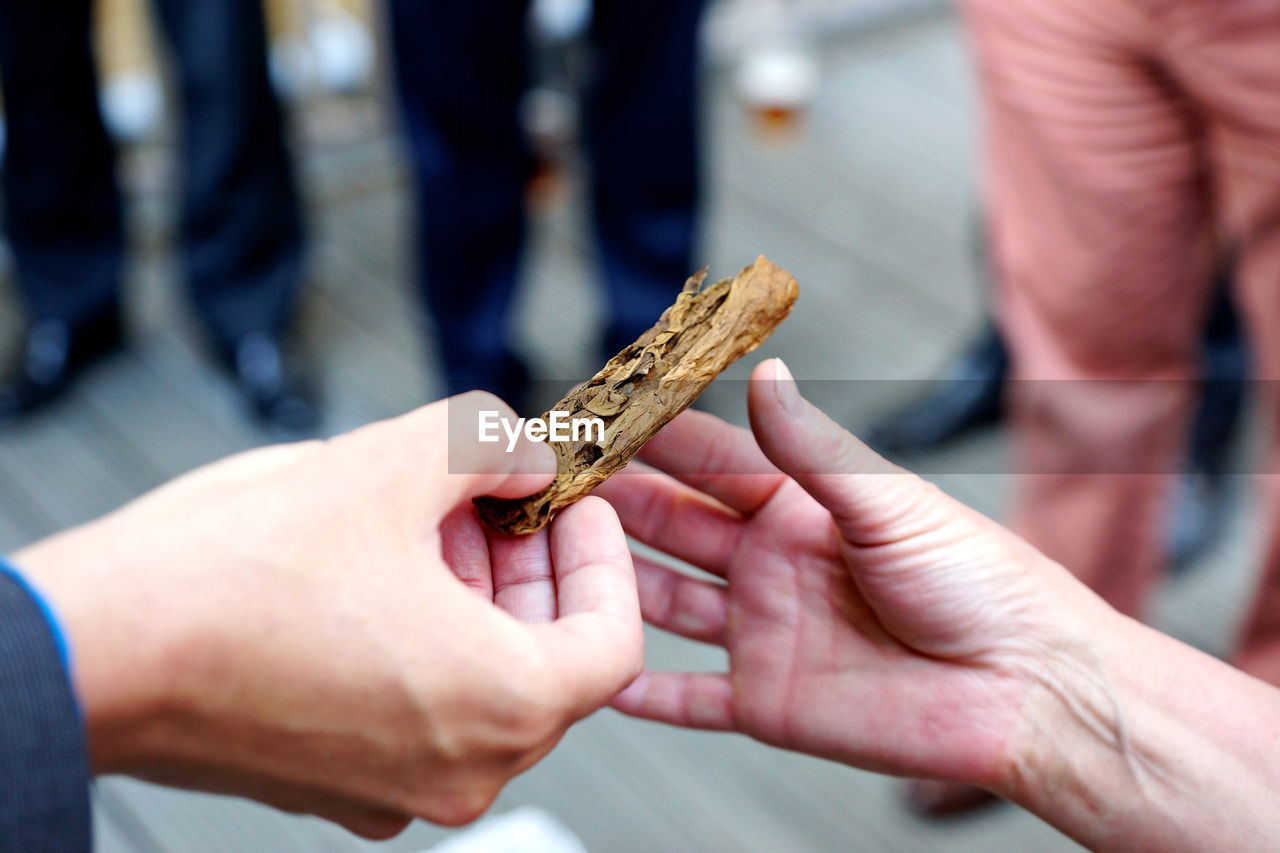 Cropped hand giving marijuana to friend