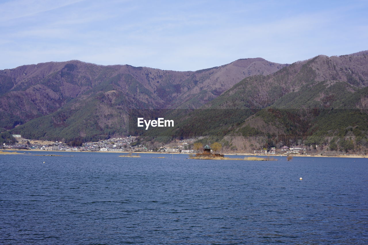SCENIC VIEW OF SEA AGAINST MOUNTAINS