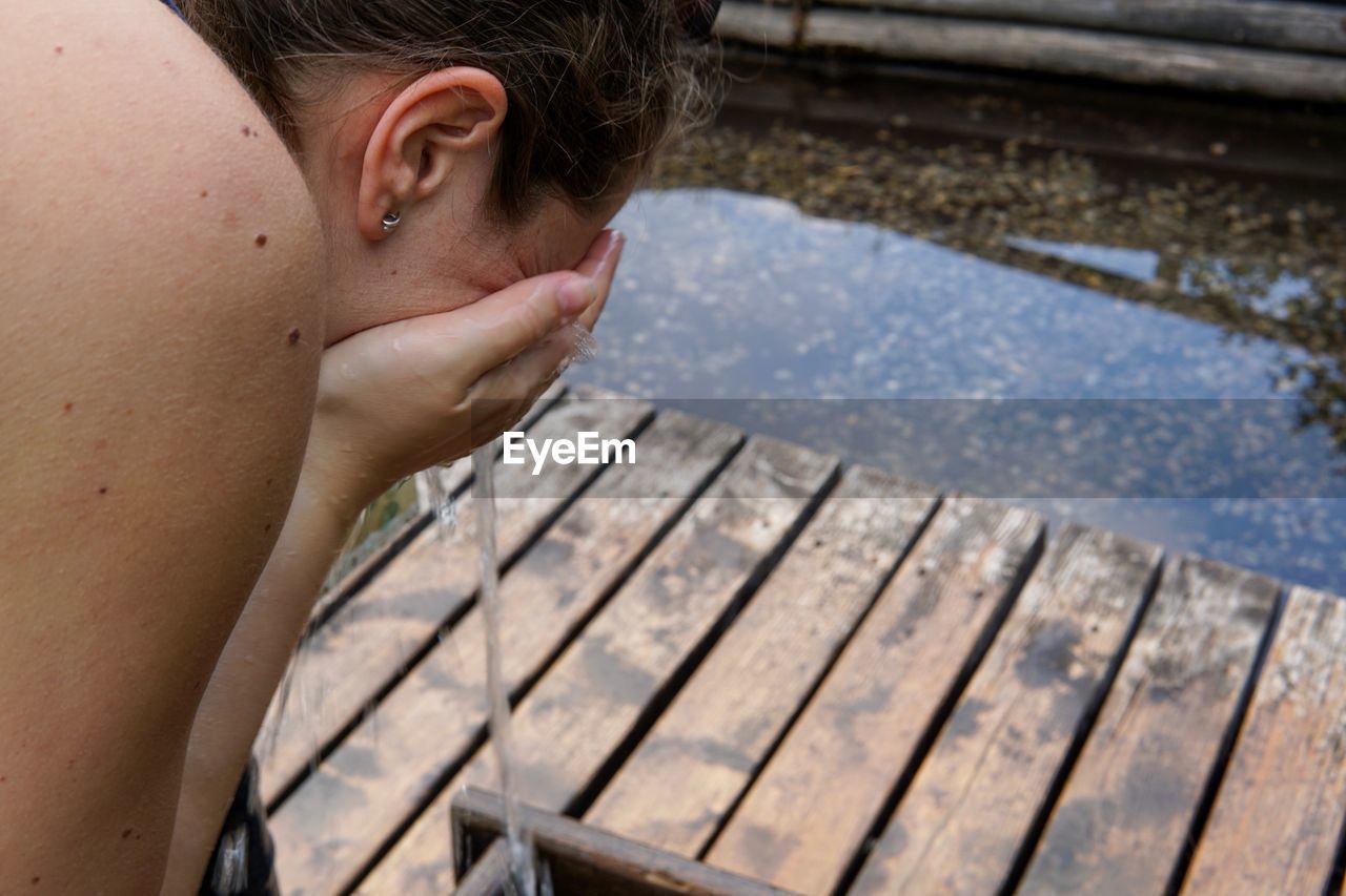 Close-up of woman washing face outdoors