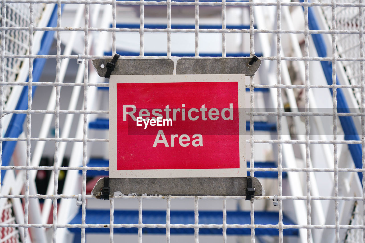 communication, text, sign, red, blue, no people, western script, metal, protection, architecture, security, warning sign, stadium, outdoors, advertising, day