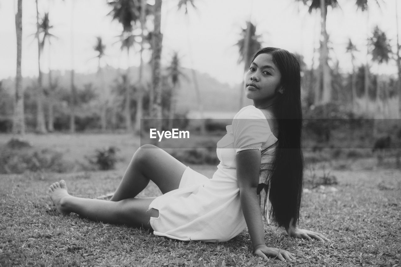 Young woman sitting on field