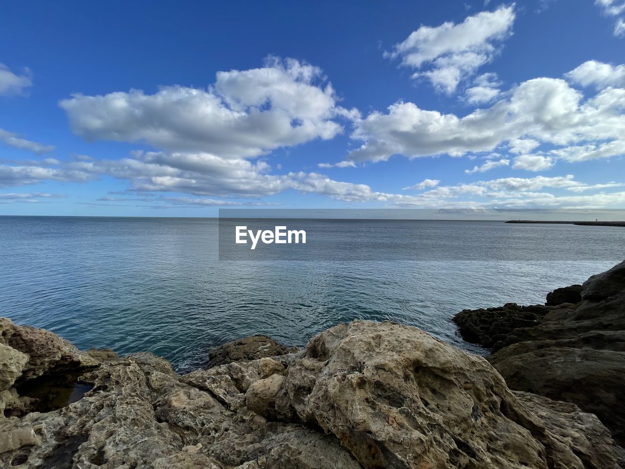 sky, water, sea, cloud, scenics - nature, shore, horizon, beauty in nature, body of water, rock, coast, land, ocean, nature, beach, tranquility, tranquil scene, blue, bay, environment, horizon over water, landscape, no people, travel destinations, day, cliff, outdoors, travel, terrain, wave, coastline, seascape, idyllic, tourism, non-urban scene, cove