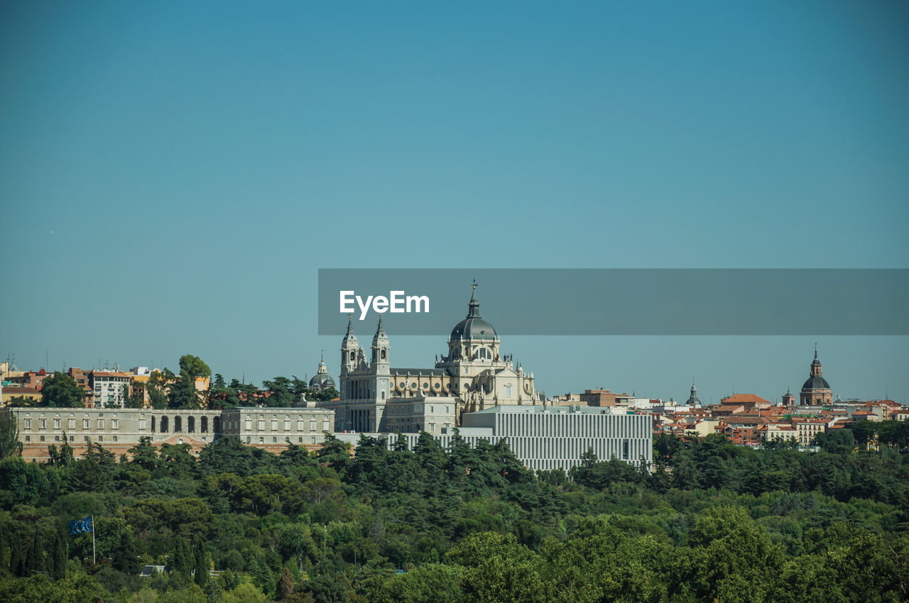 Royal palace and almudena cathedral on the horizon seen from the teleferico park of madrid, spain.