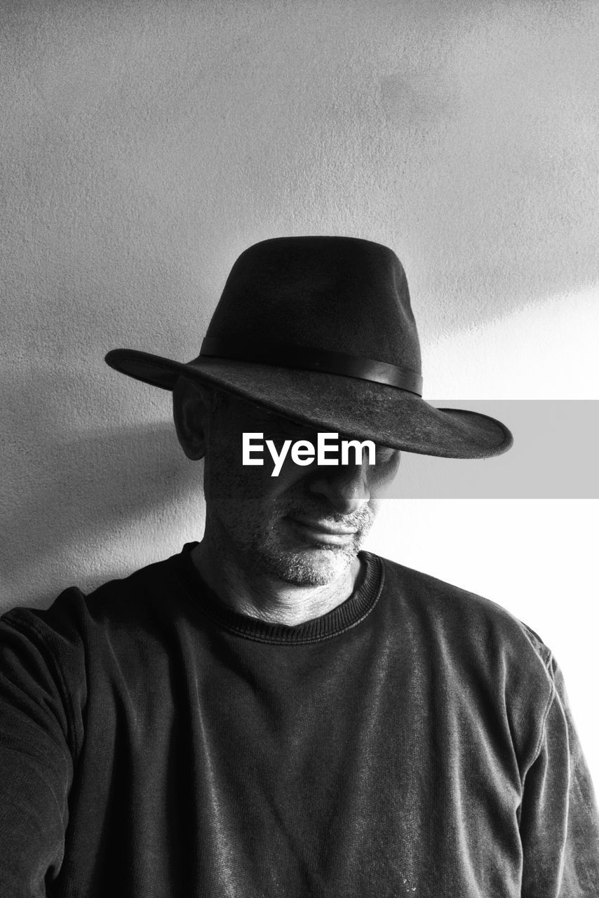 black, one person, hat, black and white, clothing, fedora, adult, cowboy hat, portrait, white, men, monochrome, monochrome photography, front view, headshot, casual clothing, fashion accessory, indoors, cowboy, person, waist up, moustache