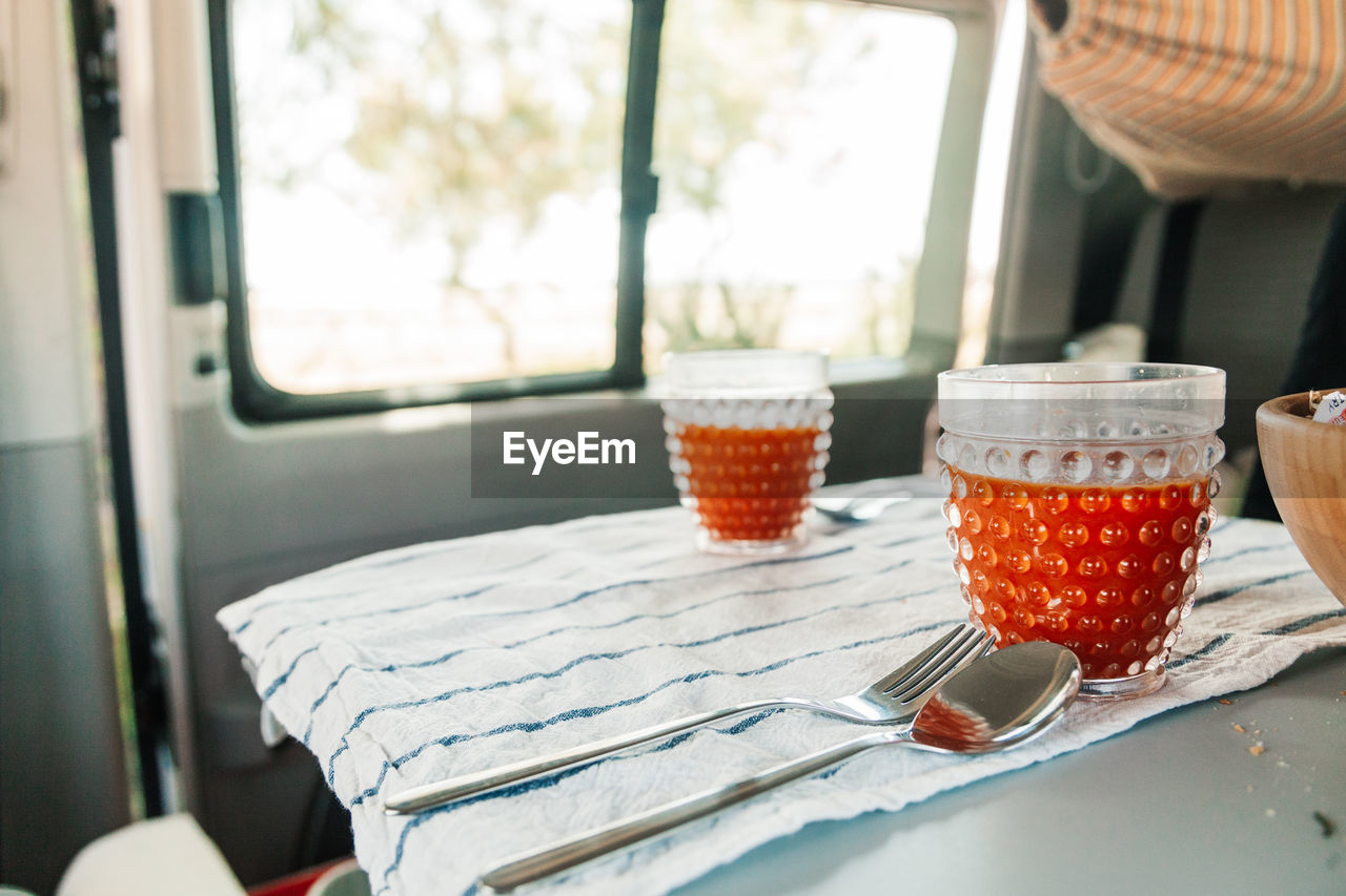 Close-up of tomato juice served on table in a camper van. 