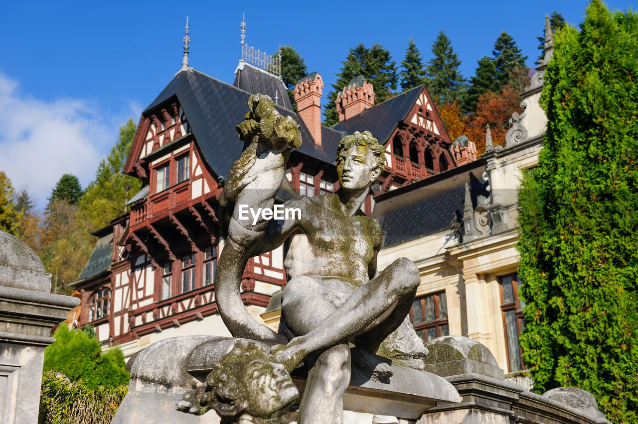 LOW ANGLE VIEW OF STATUE AGAINST BUILT STRUCTURE