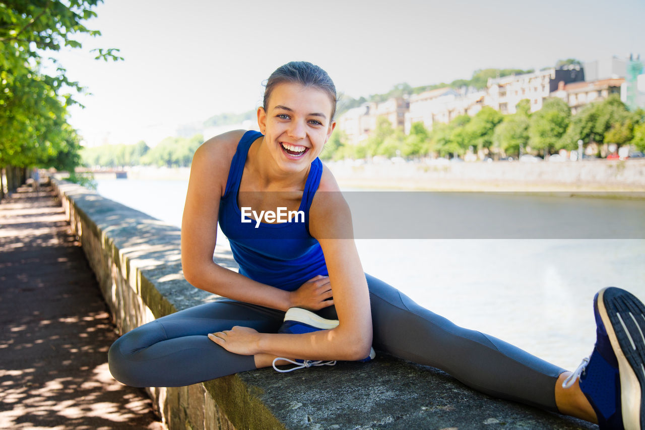 Portrait of teenage girl exercising on retaining wall