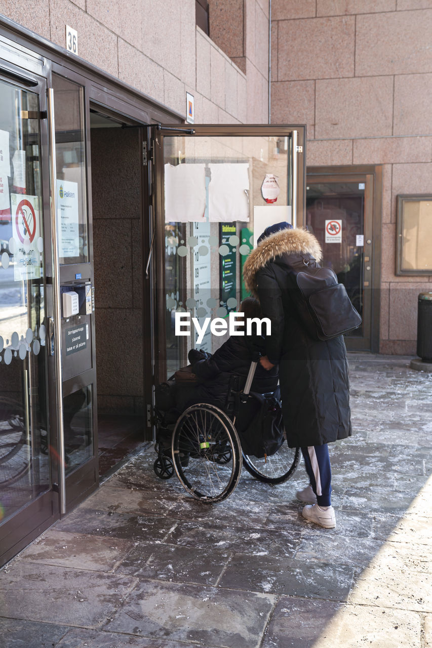 Carer pushing woman on wheelchair