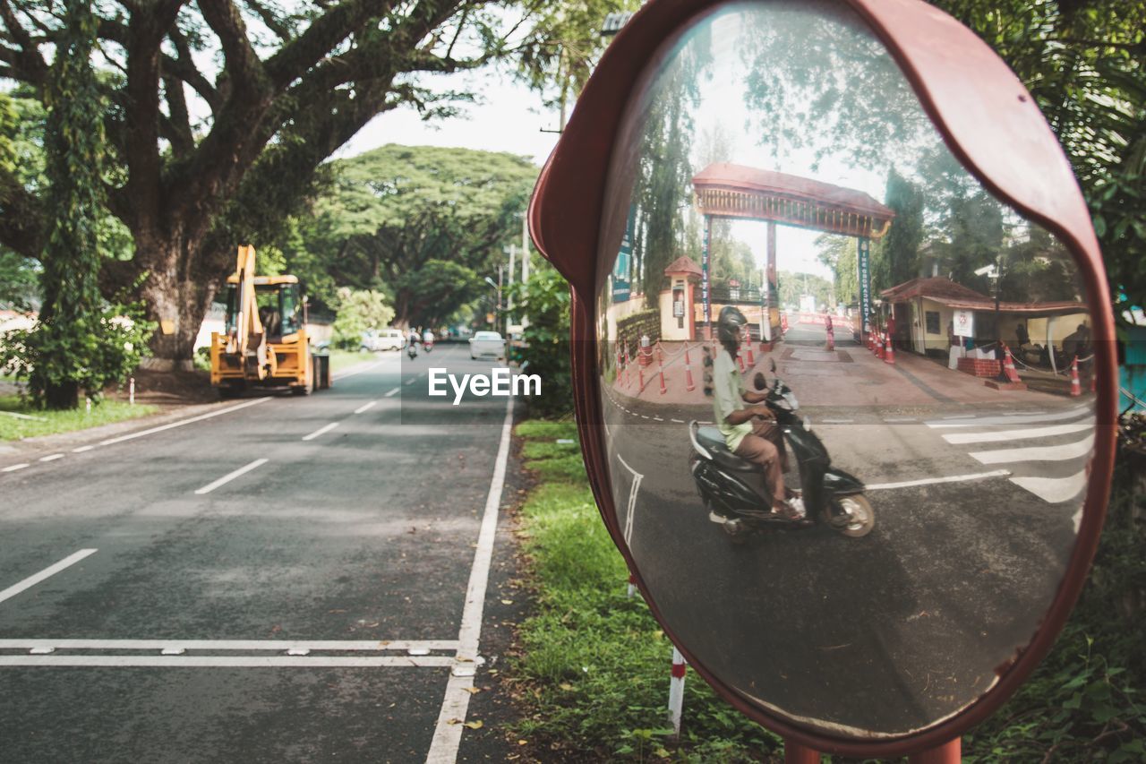 Man driving motorcycle reflecting in mirror