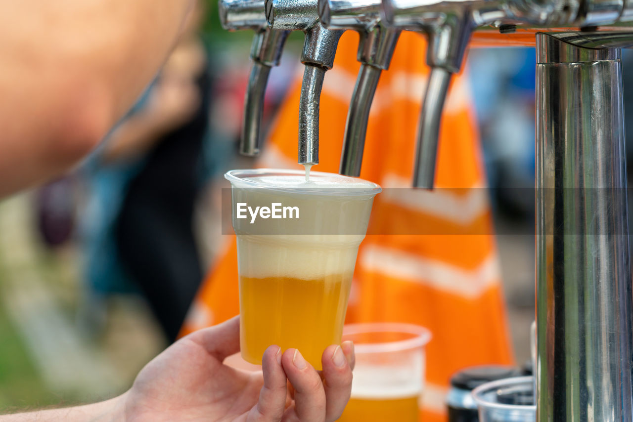 cropped hand of man holding beer glass