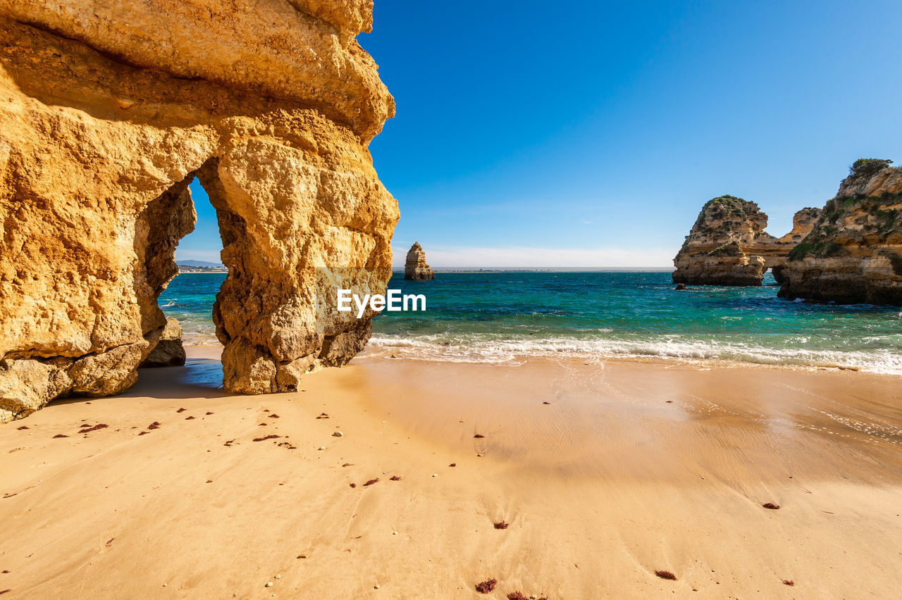 ROCKS ON BEACH AGAINST SKY