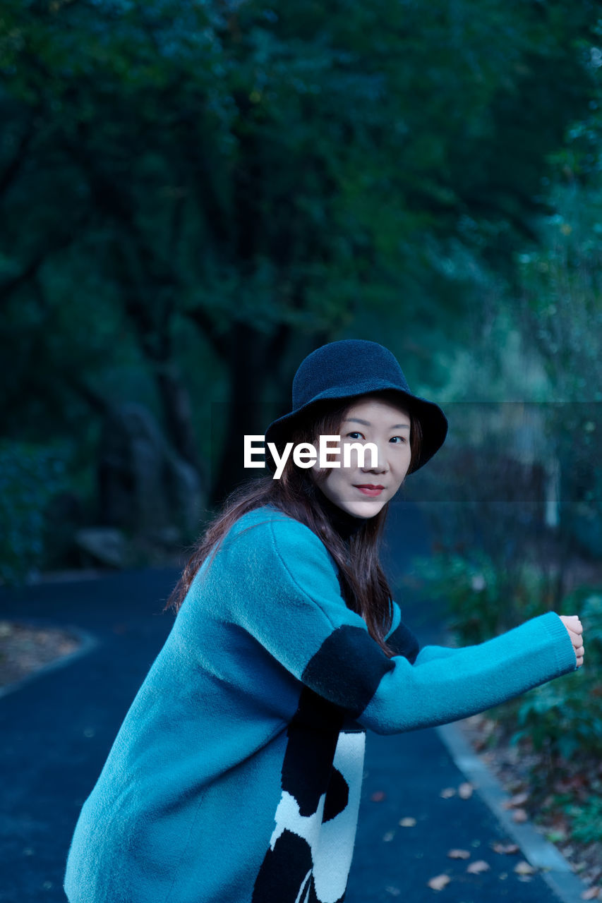 Portrait of smiling woman standing on road 