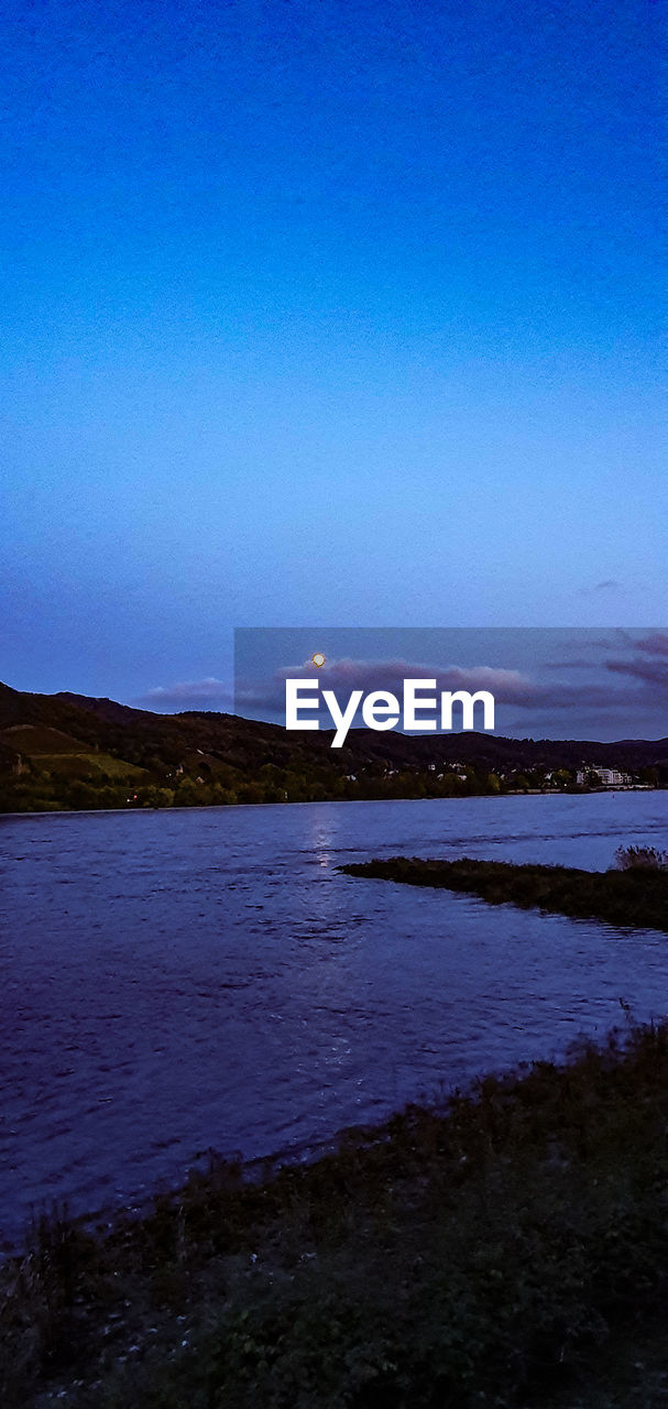 SCENIC VIEW OF LAKE AGAINST SKY AT DUSK